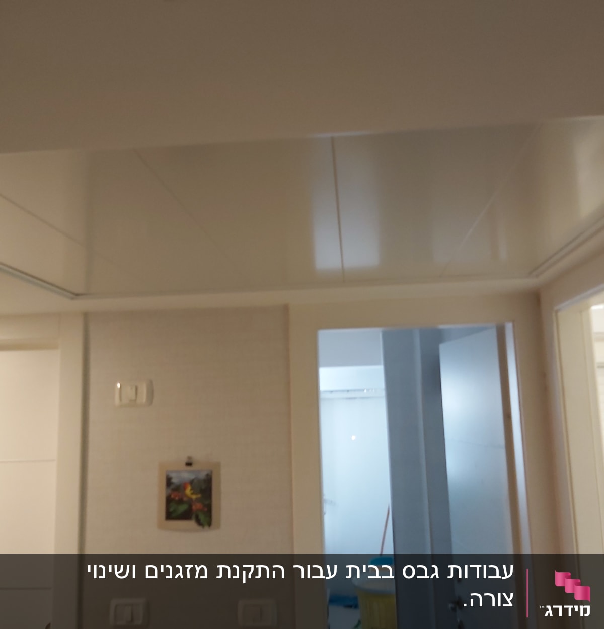 קיר גבס עם מתגי חשמל ותמונה תלויה
